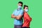 Reliable friendship. Cheerful young couple of friends with surgical medical mask standing back to back with crossed hands and