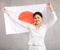Reliant positive young woman holds big national flag of Japan with confident smile showing teeth