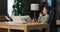 Relief calm young woman in buisness suit sitting at table at home home office. Freelancer calling having conference