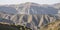 Relief slopes and ridges in mountains with vegetation and rocky ledges in autumn