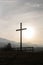 Religion theme, view of catholic cross silhouette, with fantastic sunset and mountains as background. Toned image