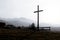 Religion theme, view of catholic cross silhouette, with fantastic sunset and mountains as background. Toned image