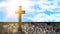 Religious background - Old stone cross and old brick stone wall in the cemetery with blue sky, clouds and sunbeams