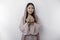 Religious beautiful Asian Muslim girl wearing a headscarf praying to God, isolated by white background