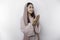 Religious beautiful Asian Muslim girl wearing a headscarf praying to God, isolated by white background