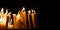Religious candle light on black background. Yellow candlelight flame in dark christian church at night