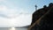 Religious christian cross standing on rock in the sea