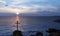 Religious christian cross standing on rock in the sea or ocean