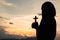 Religious concepts. Silhouette of a girl holding a crucifix to God. Morning with beautiful sunrise, Symbol of Faith. Christian