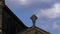 Religious cross on old English Church roof time lapse