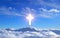 Religious cross over cumulus clouds illuminated by the rays of holy radiance, concept.