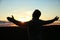 Religious man praying outdoors at sunset