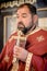 Religious priest holds holy Christian cross during religious chuch ceremony