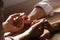 Religious women holding hands and praying together at wooden table, closeup