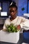 Relocated african american businesswoman putting objects in cardboard box