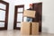 Relocation worker with cardboard boxes in apartment