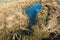 Remaining water of narrow river on the field of dried grass