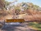 Remains of a burned down foot bridge and a warning sign after bush fire in an suburban area