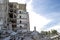 The remains of the destroyed concrete building against the textured blue sky. Space for text. Background