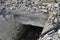 The remains of a destroyed tunnel with a pile of concrete stones destroyed building. Background