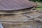 The remains of an old, destroyed metal roof lie on the ground after the demolition of the barn. Day