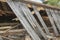 The remains of an old, destroyed roof lie on the ground after the demolition of the barn. Day.