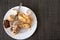 The remains of pastries and cake in a plate on the table. Harmful delicious sweet food. Close-up, copy space for text