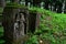 Remains of two ancient gravestones outgrowing with moss, one of them with religious sculpture, located on Island Of Art