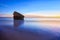 Remains of the watchtower on the shore of the beach at sunset