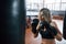 Remember to breathe properly. Female boxer is punching the bag. Blonde have exercise in the gym