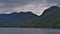 Remote aquaculture facilities on the shore of Princess Royal Island in front of mountains near Inside Passage in BC, Canada.