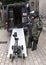 Remote bomb disposal robot used by police and officer wearing heavy blast suit