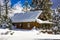 Remote Cabin With Snow Piled High On Roof