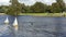 Remote controlled sailing wooden yachts race in a pond