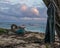 Remote Jamaican beach wth abandoned fishing boat and shirt on tree.