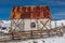 Remote metal barn surrounded by junk cars in snowy area of central Colorado