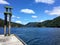 A remote photo of a wooden dock spcae for a boat surrounded by beautiful ocean and forested mountains in saanich inlet, Vancouver