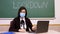 Remote teaching, lockdown at schools. Online schooling, e-learning. Female teacher, in protective mask, is holding