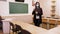Remote teaching, lockdown at schools. woman teacher, in a protective mask, stands in an empty school classroom with a