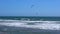 Remote view at kite surfers riding the waves