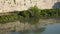 Remote view of Tiber river in Italy flows through Rome, built up in front of brick wall as waterfront