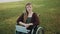 Remote work concept. Young disabled woman in the wheelchair using smartphone and laptop