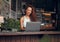 Remote work, laptop and woman at restaurant typing blog article with satisfied and happy smile. Freelance blogger girl