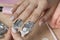 Remove the gel polish with foil. Woman pours remove liquid on a cotton pad, puts it on a nail and wraps the foil. Removing shellac