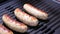 Removing sausages from the grill close up. 4K resolution video. Delicious Fried Roasting Grilled Meat Dish Ready For Picnic or Par