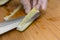 Removing the seed pit and core of a cucumber with a sharp stainless knife while wearing plastic gloves