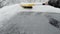 Removing snow from a car window using a brush. Brushing the windshield from snow.