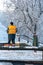 Removing snow from the sidewalk after snowstorm. A road worker with a shovel in his hands and in special clothes cleans the