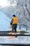 Removing snow from the sidewalk after snowstorm. A road worker with a shovel in his hands and in special clothes cleans the