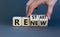 Renew and restart symbol. Businessman hand turns cubes and changes the word `renew` to `restart`. Beautiful grey background.